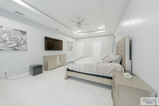 bedroom with a tray ceiling and ceiling fan