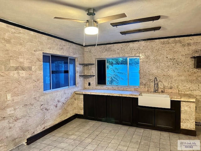 kitchen with decorative light fixtures, ceiling fan, ornamental molding, and sink