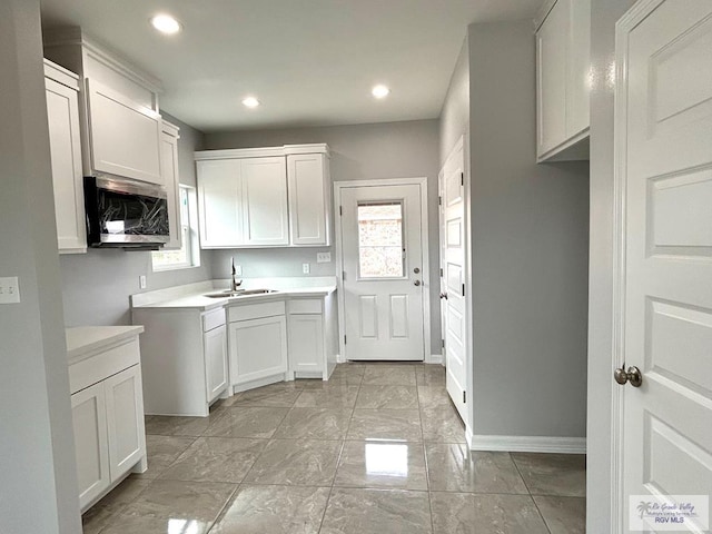 kitchen with white cabinetry and sink