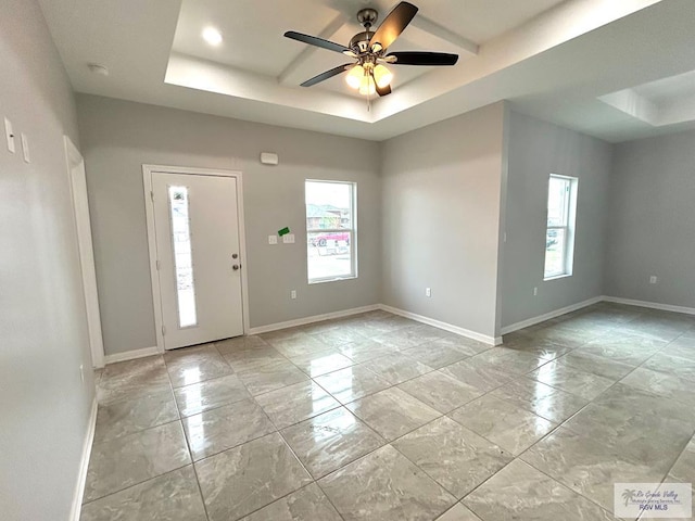 foyer entrance featuring a tray ceiling and ceiling fan