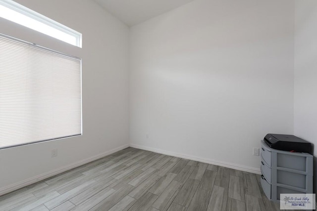 unfurnished room with baseboards and wood finished floors