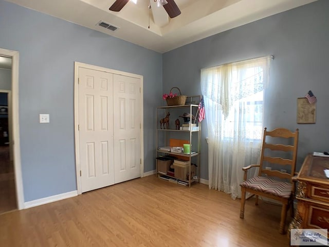 living area with light hardwood / wood-style floors and ceiling fan