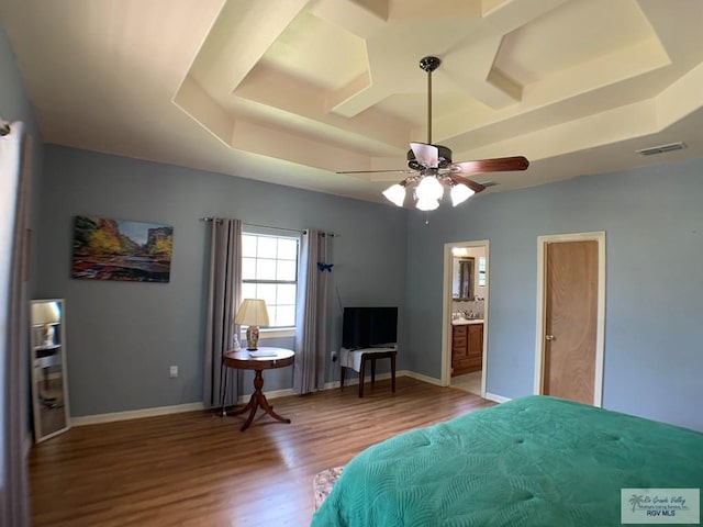 bedroom featuring a raised ceiling, connected bathroom, ceiling fan, and hardwood / wood-style flooring