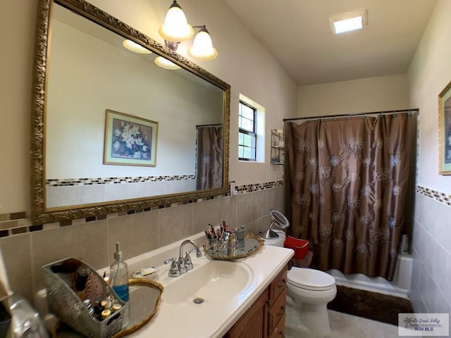 full bathroom with vanity, toilet, tile walls, and shower / bath combo with shower curtain