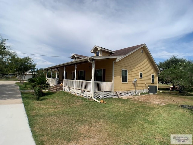 view of side of property with central AC unit, covered porch, and a yard