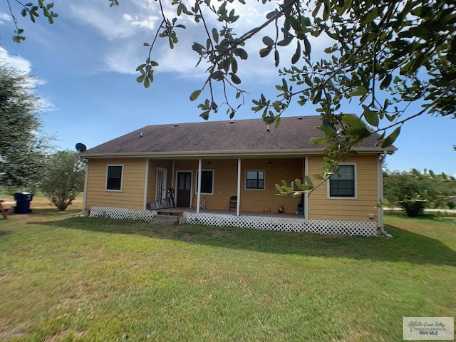 rear view of house featuring a lawn