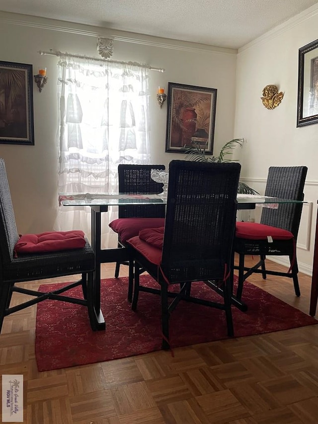 dining room featuring parquet flooring, a textured ceiling, and ornamental molding