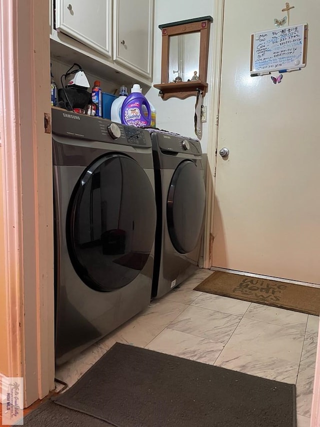 laundry room featuring separate washer and dryer and cabinets