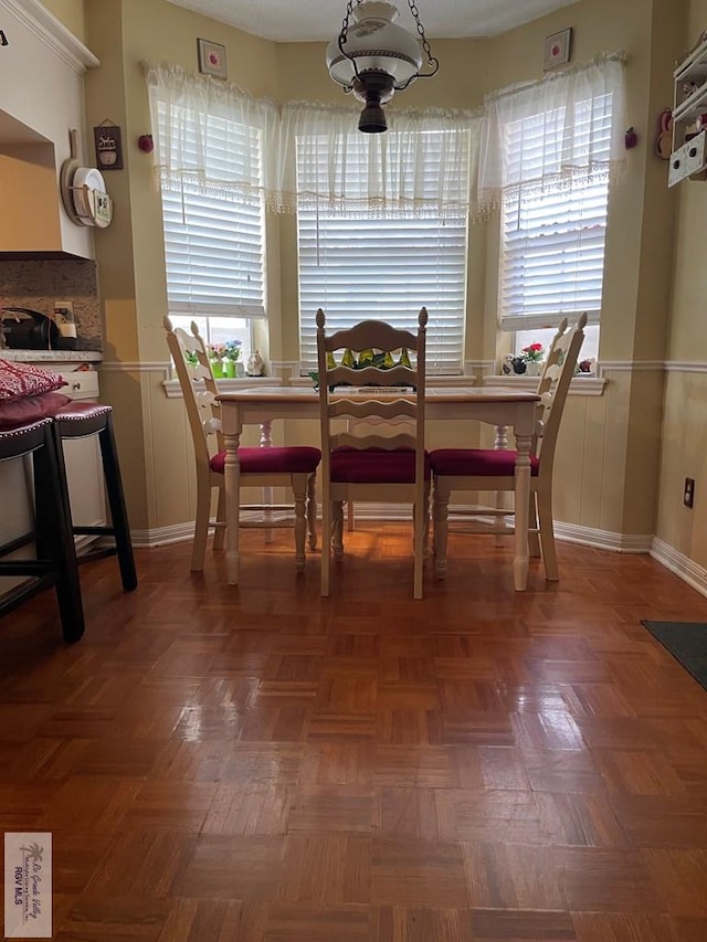 dining space featuring dark parquet floors