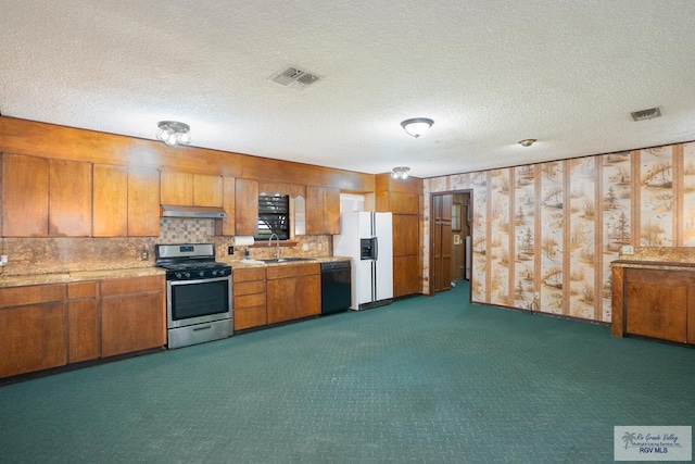 19863 Tilden Rd, San Benito, TX 78586 - kitchen featuring stainless steel range with gas stovetop, dishwasher, under cabinet range hood, a sink, and white refrigerator with ice dispenser