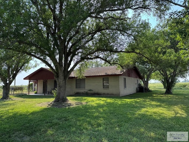 19863 Tilden Rd, San Benito, TX 78586 - view of front of property featuring brick siding, a front lawn, and central AC