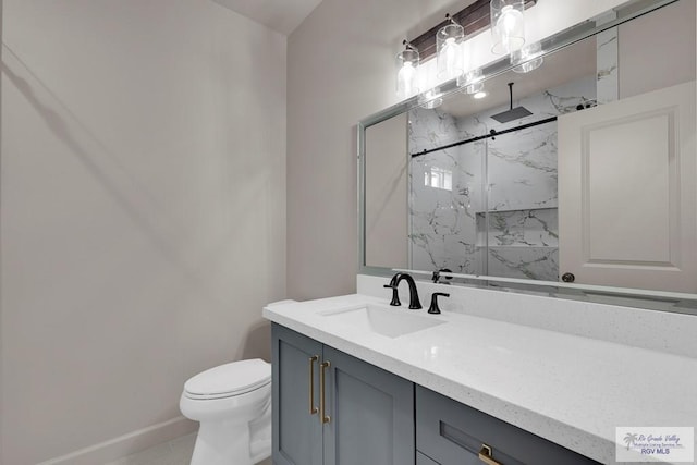 bathroom with a marble finish shower, baseboards, toilet, and vanity