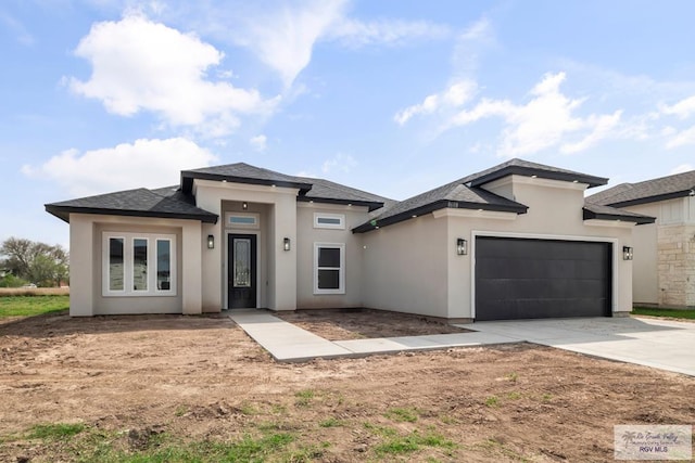 prairie-style home with an attached garage, driveway, and stucco siding