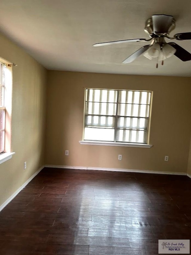 empty room featuring dark wood-type flooring and a healthy amount of sunlight