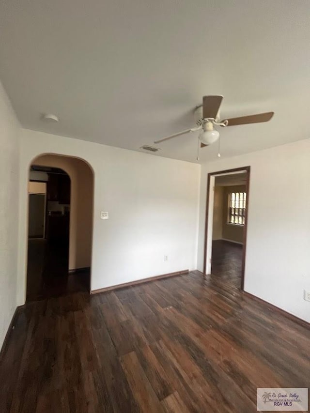 unfurnished room with ceiling fan and dark hardwood / wood-style flooring