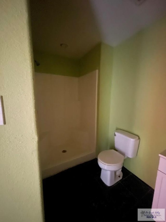 bathroom with tile patterned floors, toilet, and walk in shower