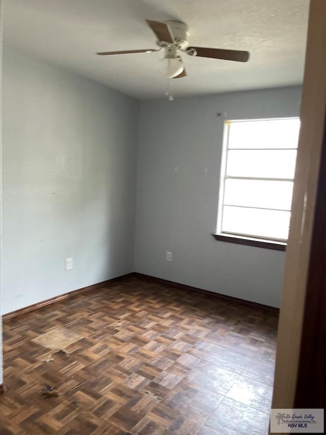 empty room featuring ceiling fan and dark wood-type flooring