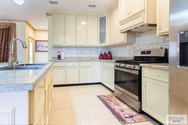 kitchen featuring light stone countertops, sink, stainless steel range with gas cooktop, premium range hood, and cream cabinets