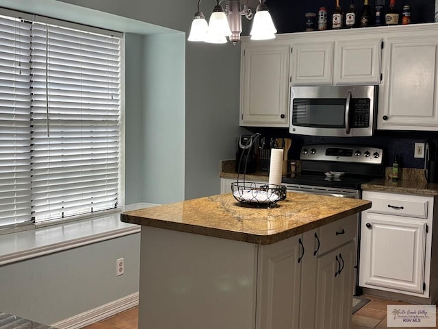 810 E Robin Ave Unit 53, Harlingen, TX 78550 - kitchen with stainless steel appliances, white cabinetry, a kitchen island, and light tile patterned flooring