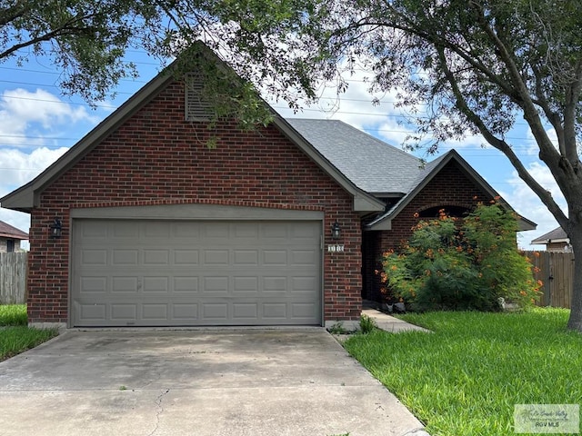 810 E Robin Ave Unit 53, Harlingen, TX 78550 - view of front facade featuring brick siding, driveway, roof with shingles, and an attached garage