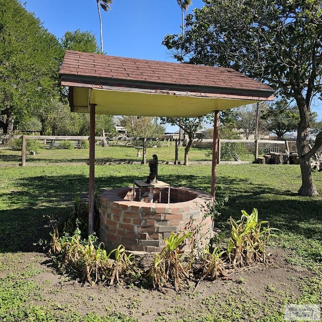 view of community featuring fence and a yard