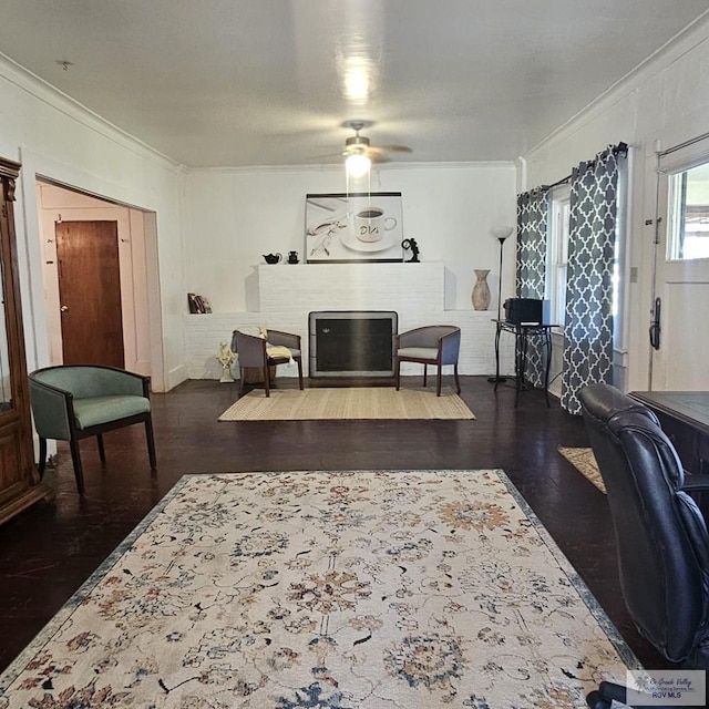 living area with dark wood-style floors, a brick fireplace, and crown molding