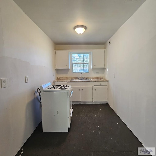 kitchen featuring light countertops, white gas range oven, a sink, and white cabinets