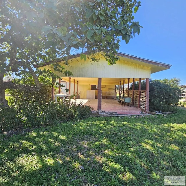 rear view of house featuring a patio area and a yard