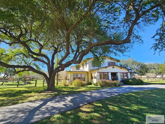 view of front of property with fence and a front lawn