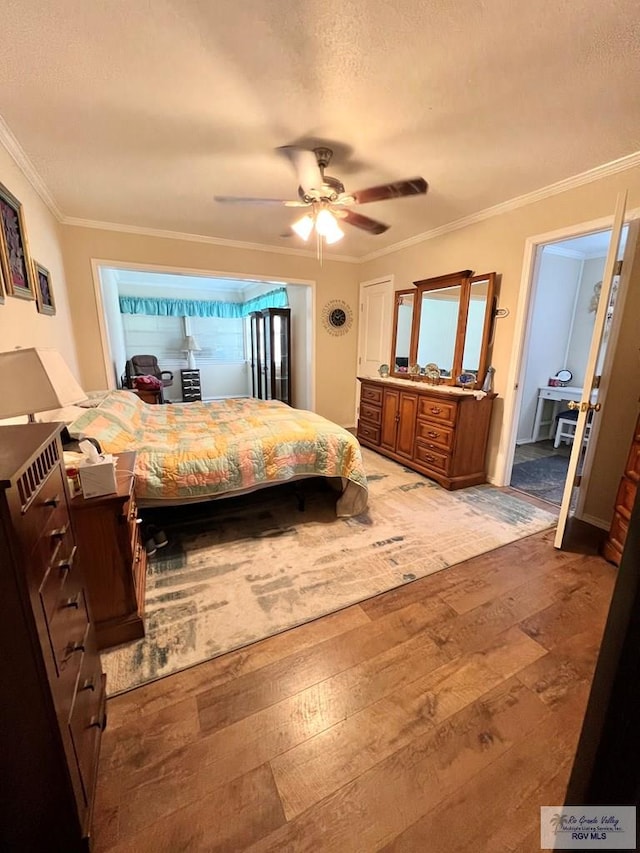 bedroom featuring ceiling fan, crown molding, wood-type flooring, and a textured ceiling