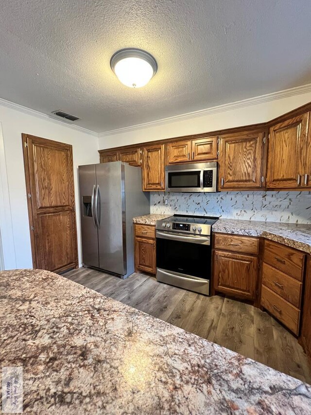 bathroom featuring hardwood / wood-style flooring, ornamental molding, and tasteful backsplash