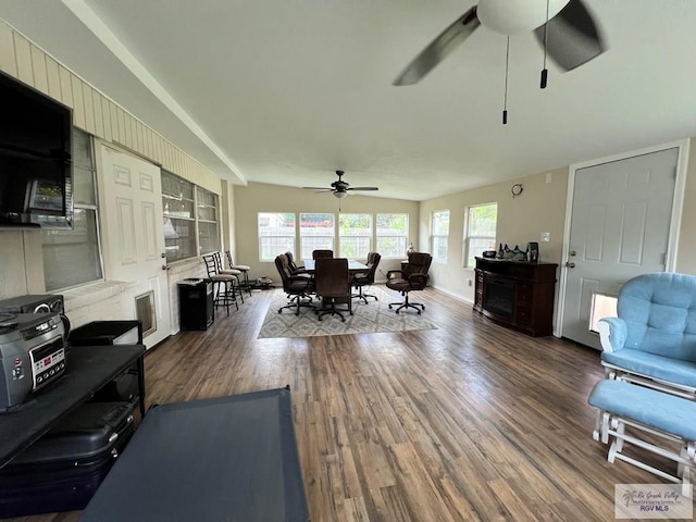 living room with dark hardwood / wood-style floors and ceiling fan