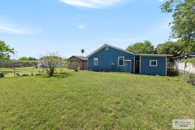 rear view of property featuring a lawn