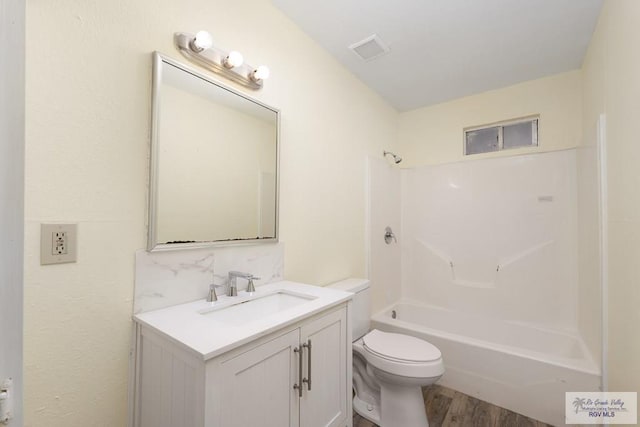 full bathroom with vanity, bathing tub / shower combination, hardwood / wood-style flooring, toilet, and tasteful backsplash