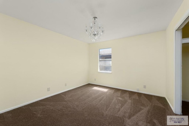 carpeted spare room with a chandelier