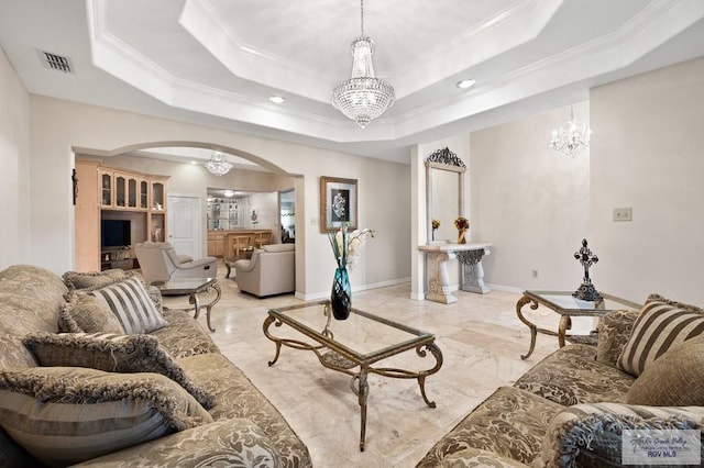 living room featuring a tray ceiling, an inviting chandelier, and crown molding