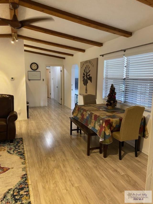 dining room featuring ceiling fan, beam ceiling, and light wood-type flooring