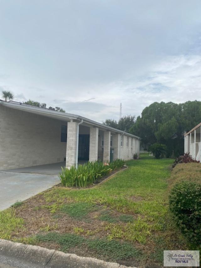 view of property exterior featuring a lawn and a carport