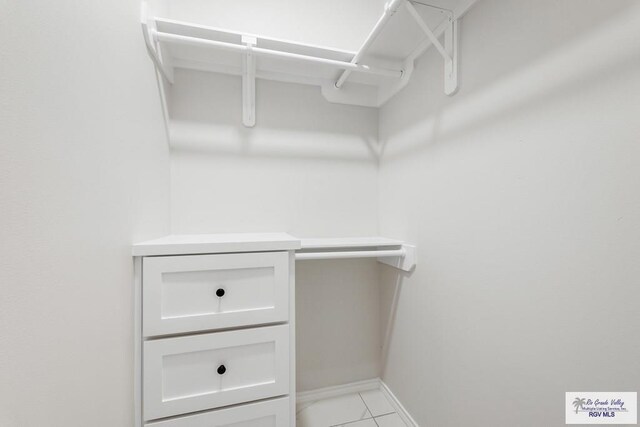 spacious closet with light tile patterned floors