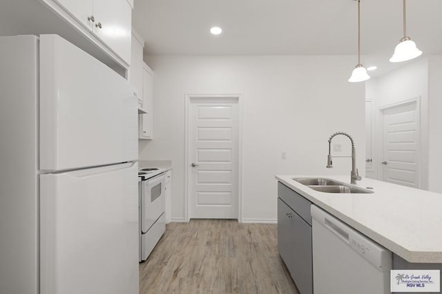 kitchen featuring sink, white cabinetry, hanging light fixtures, an island with sink, and white appliances