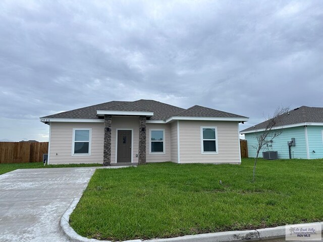 view of front of house featuring central AC and a front lawn