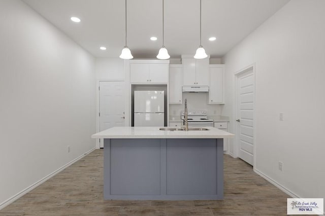 kitchen featuring sink, white appliances, a kitchen island with sink, white cabinetry, and decorative light fixtures