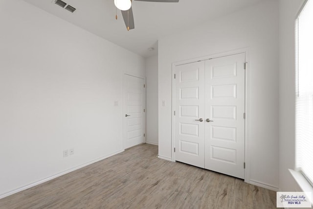 unfurnished bedroom featuring ceiling fan, a closet, and light wood-type flooring