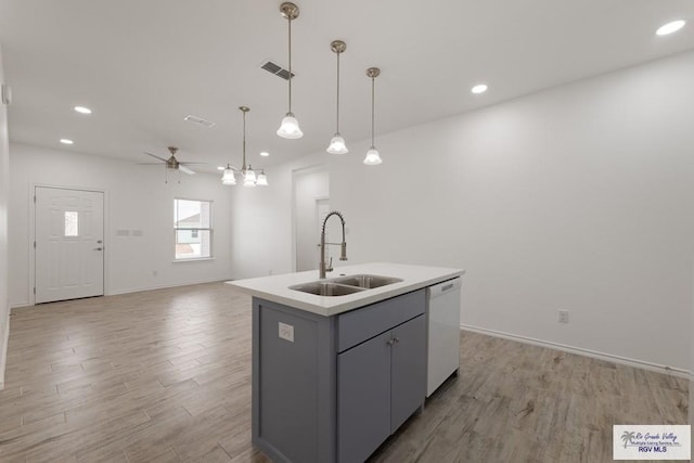 kitchen with gray cabinets, pendant lighting, an island with sink, sink, and dishwashing machine