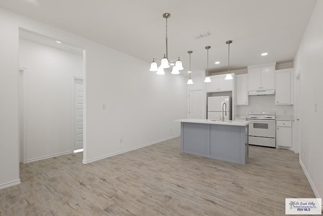 kitchen with decorative light fixtures, light hardwood / wood-style flooring, a center island with sink, white appliances, and white cabinets