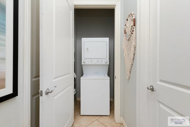 laundry room with light tile patterned floors and stacked washing maching and dryer