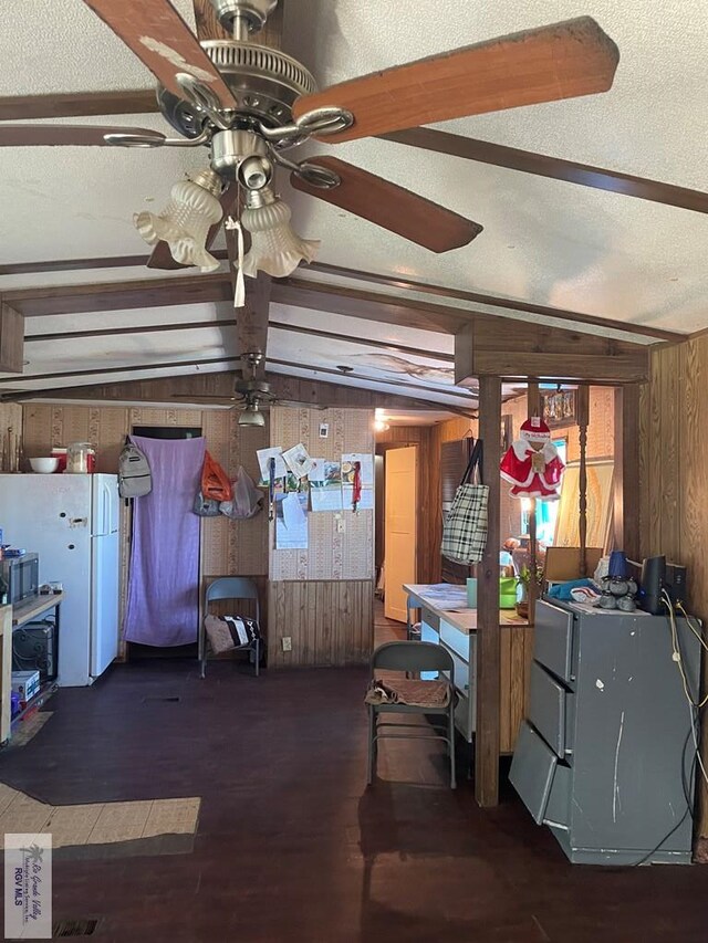 interior space with vaulted ceiling with beams, wooden walls, dark wood-type flooring, and a textured ceiling