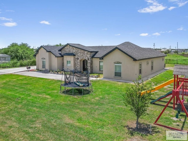 view of front facade featuring a trampoline, a patio area, a playground, and a front lawn