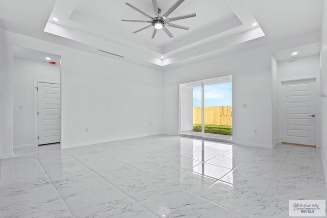 7332 San Andres St, Brownsville, TX 78520 - spare room featuring a tray ceiling, ceiling fan, recessed lighting, baseboards, and light marble finish flooring