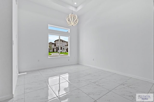 7332 San Andres St, Brownsville, TX 78520 - empty room featuring marble look tile flooring, a chandelier, baseboards, a high ceiling, and recessed lighting